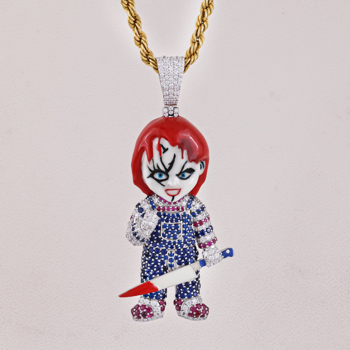 Pendant shaped like a character with red hair, blue eyes, and a knife on a light gray background