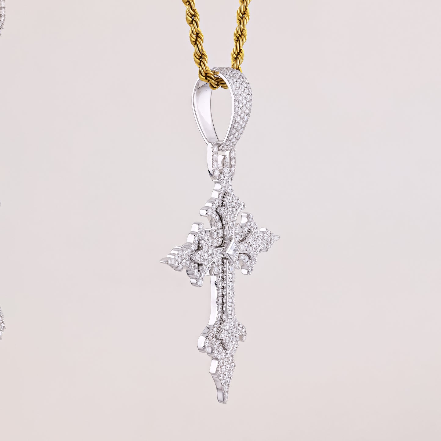 Diamond pendant on a gold chain against a light gray background