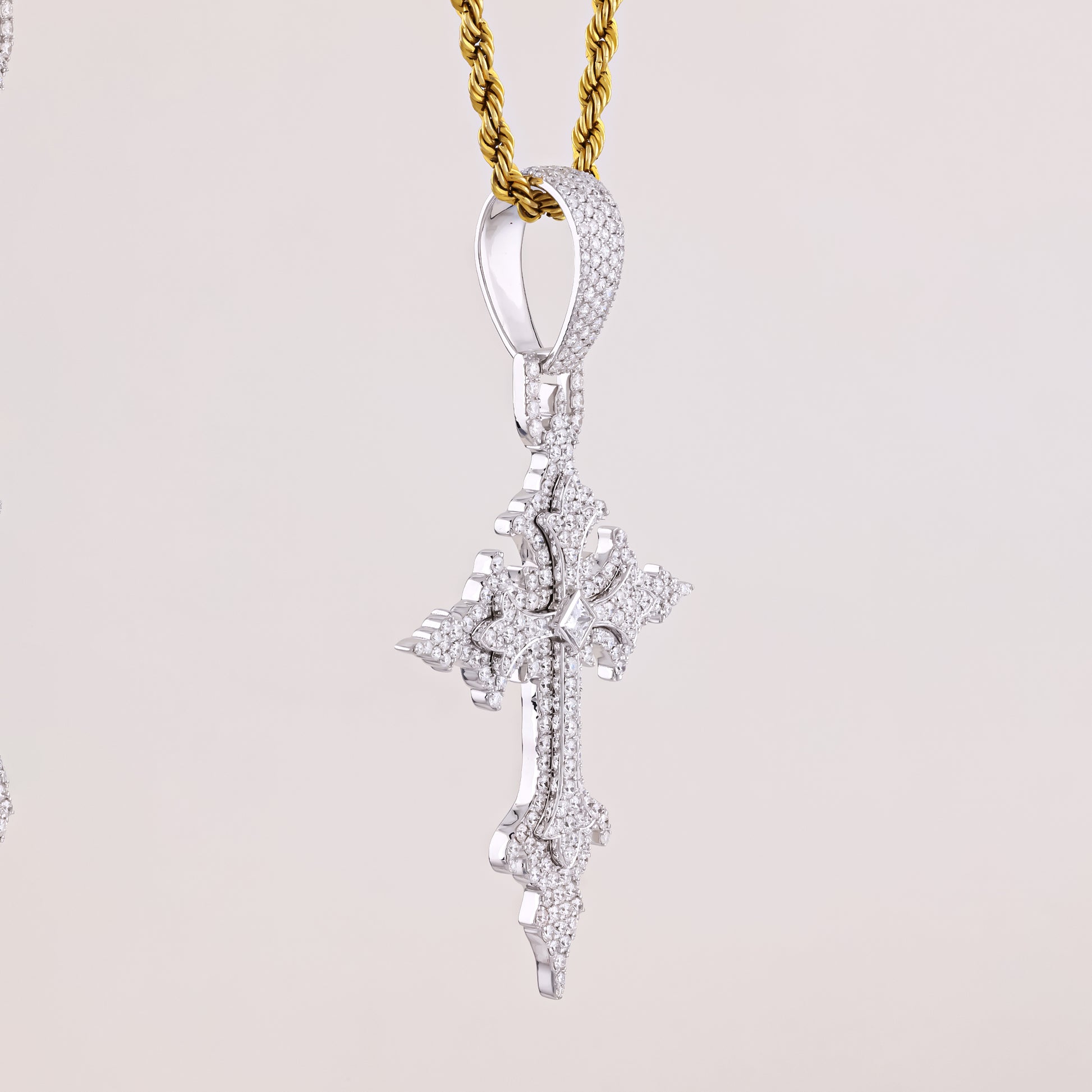 Diamond pendant on a gold chain against a light gray background