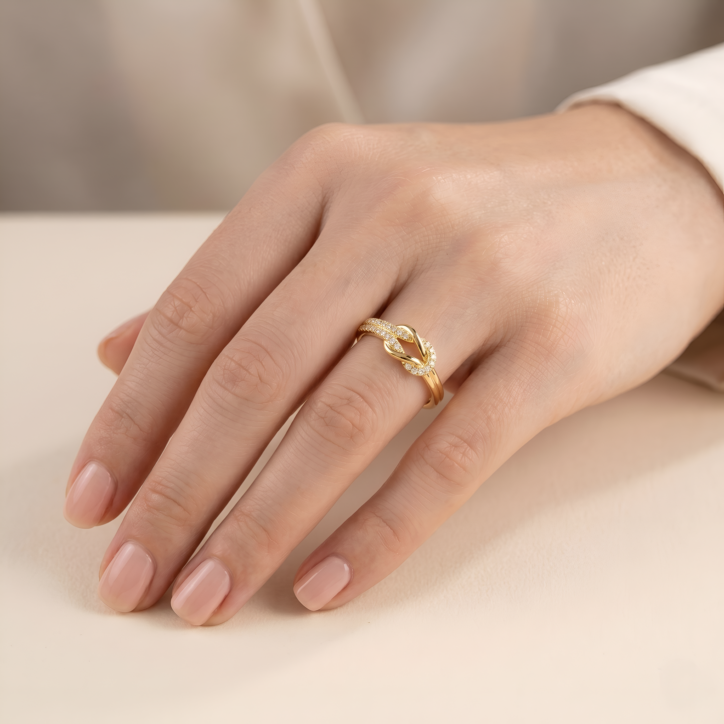 Gold ring on a person's finger against a neutral background