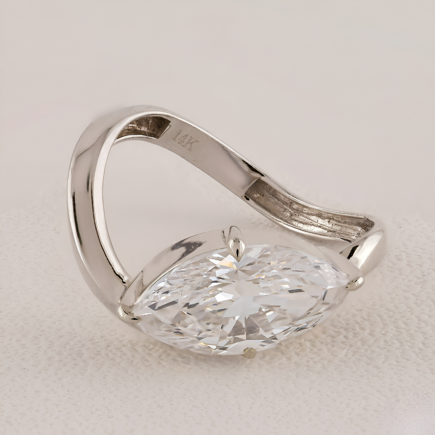 Silver ring with a large diamond on a light background