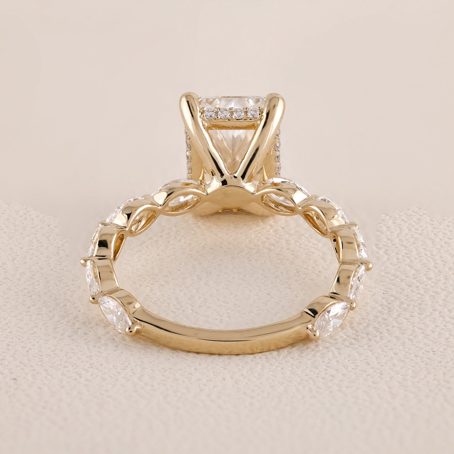 Gold ring with diamond accents on a beige background