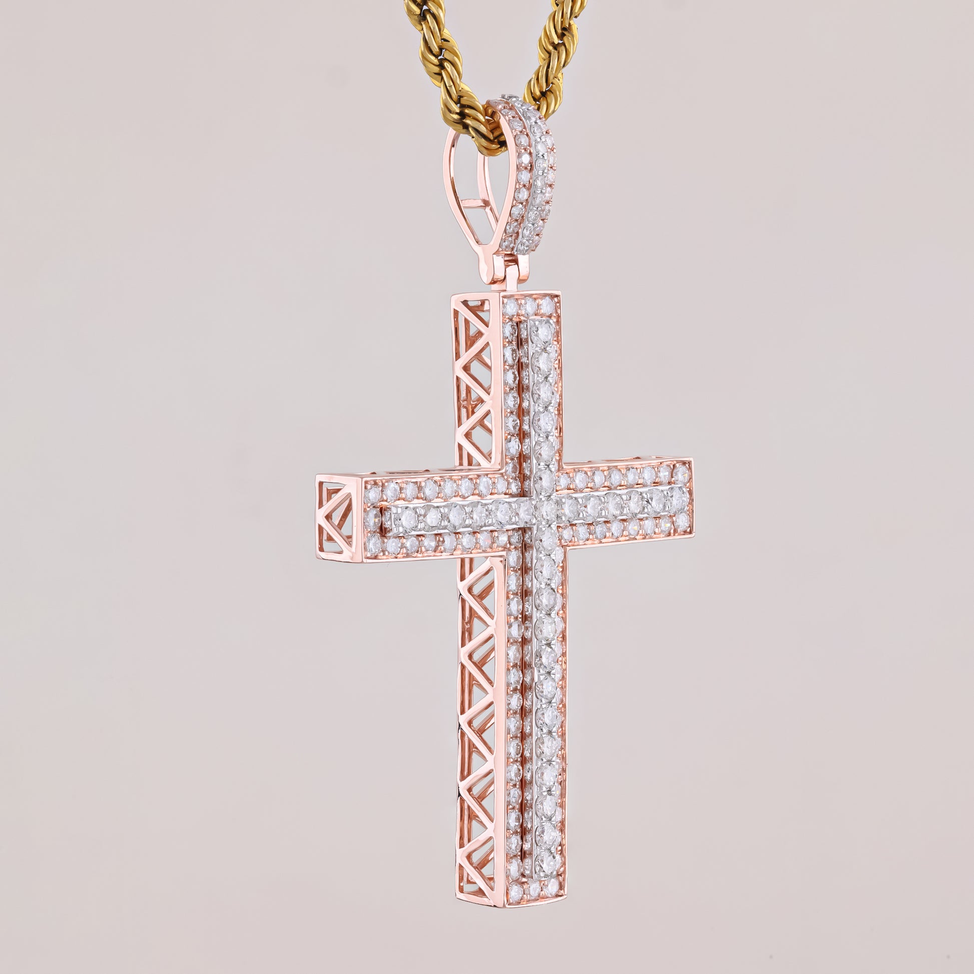 Rose gold cross pendant with diamonds on a light gray background