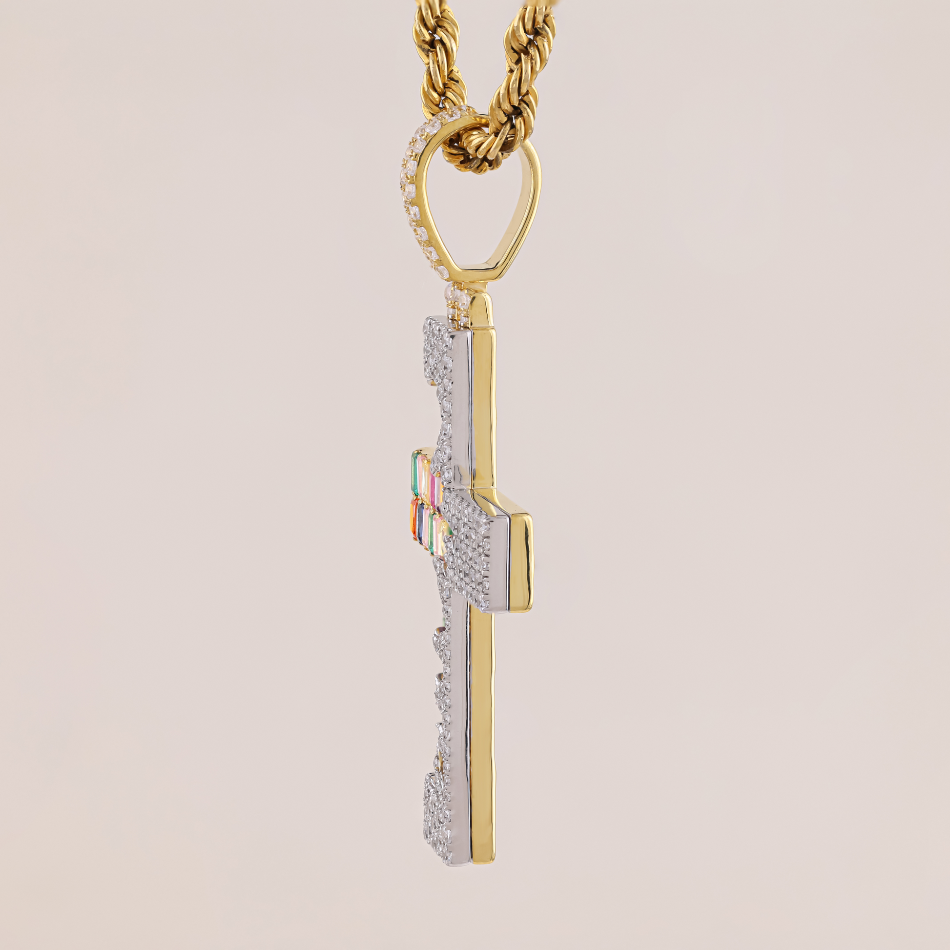 Gold and silver pendant necklace on a beige background