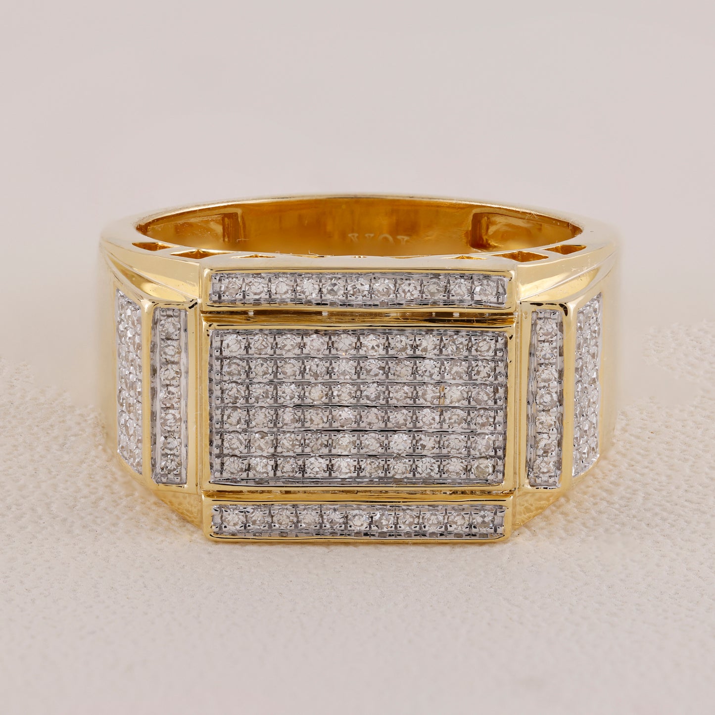 Gold ring with diamond accents on a light gray background