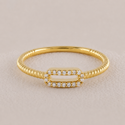 Gold ring with diamond accents on a beige background