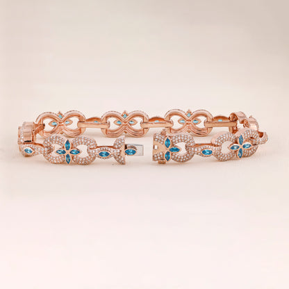 Rose gold bracelet with blue gemstones on a light beige background