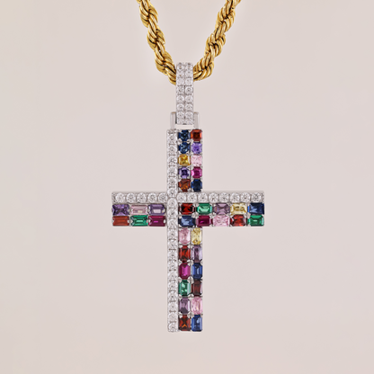 Cross-shaped pendant with colorful gemstones and a gold chain on a beige background
