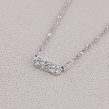 Silver necklace with a bar pendant on a light gray background
