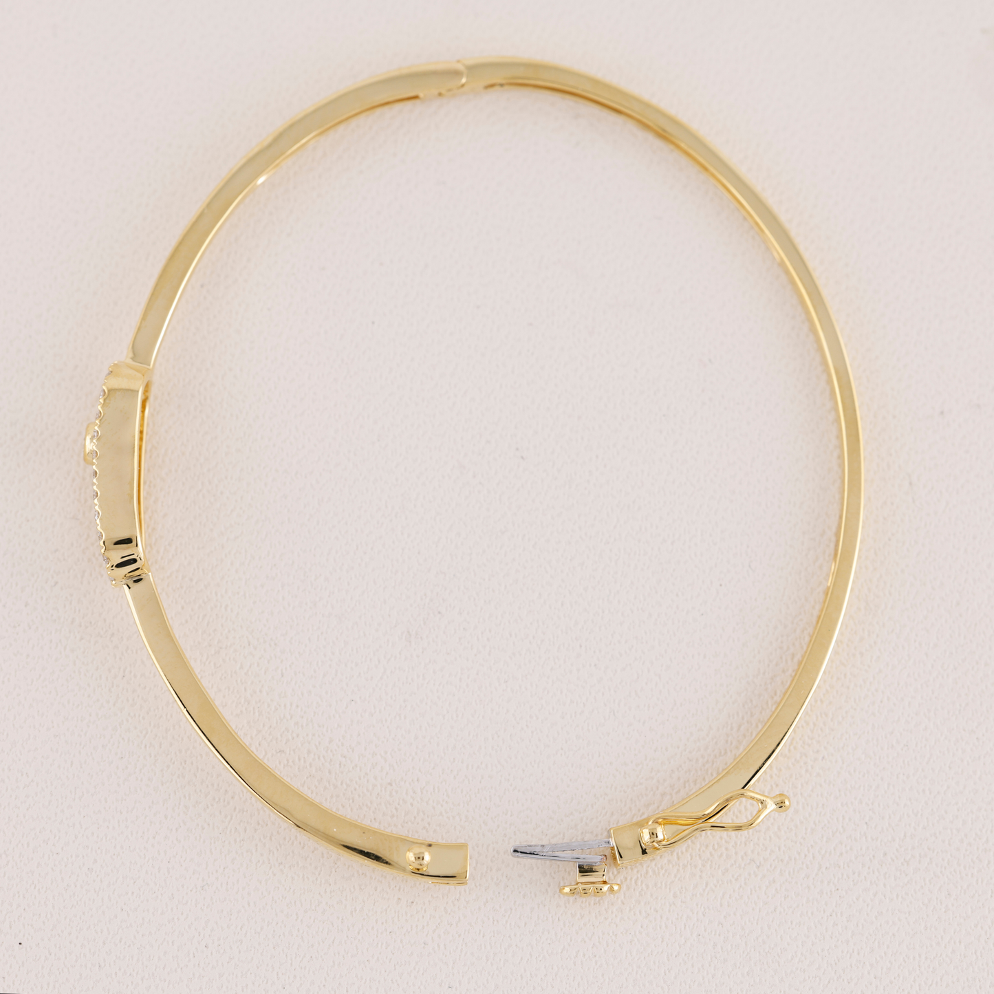 Gold bangle on a light beige background