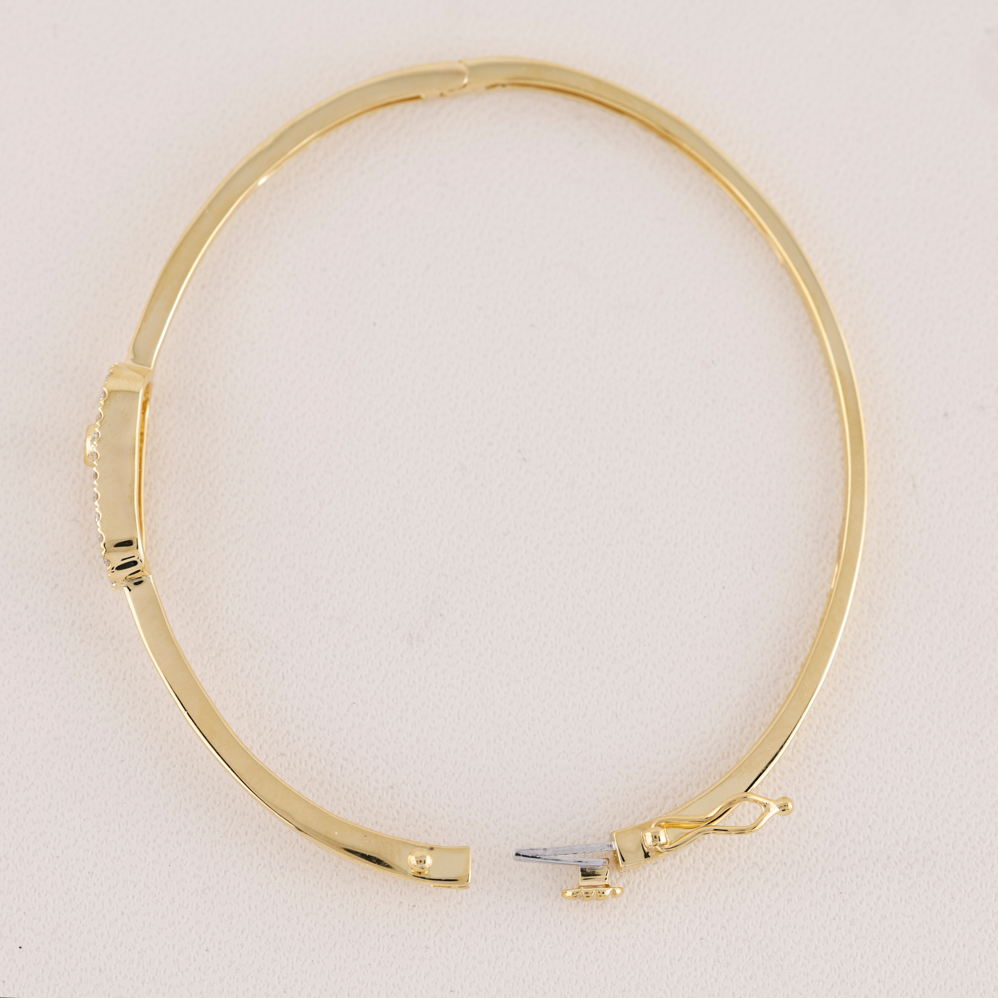Gold bangle on a light beige background