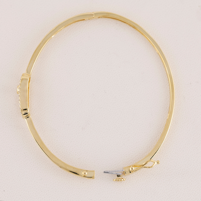 Gold bangle on a light beige background