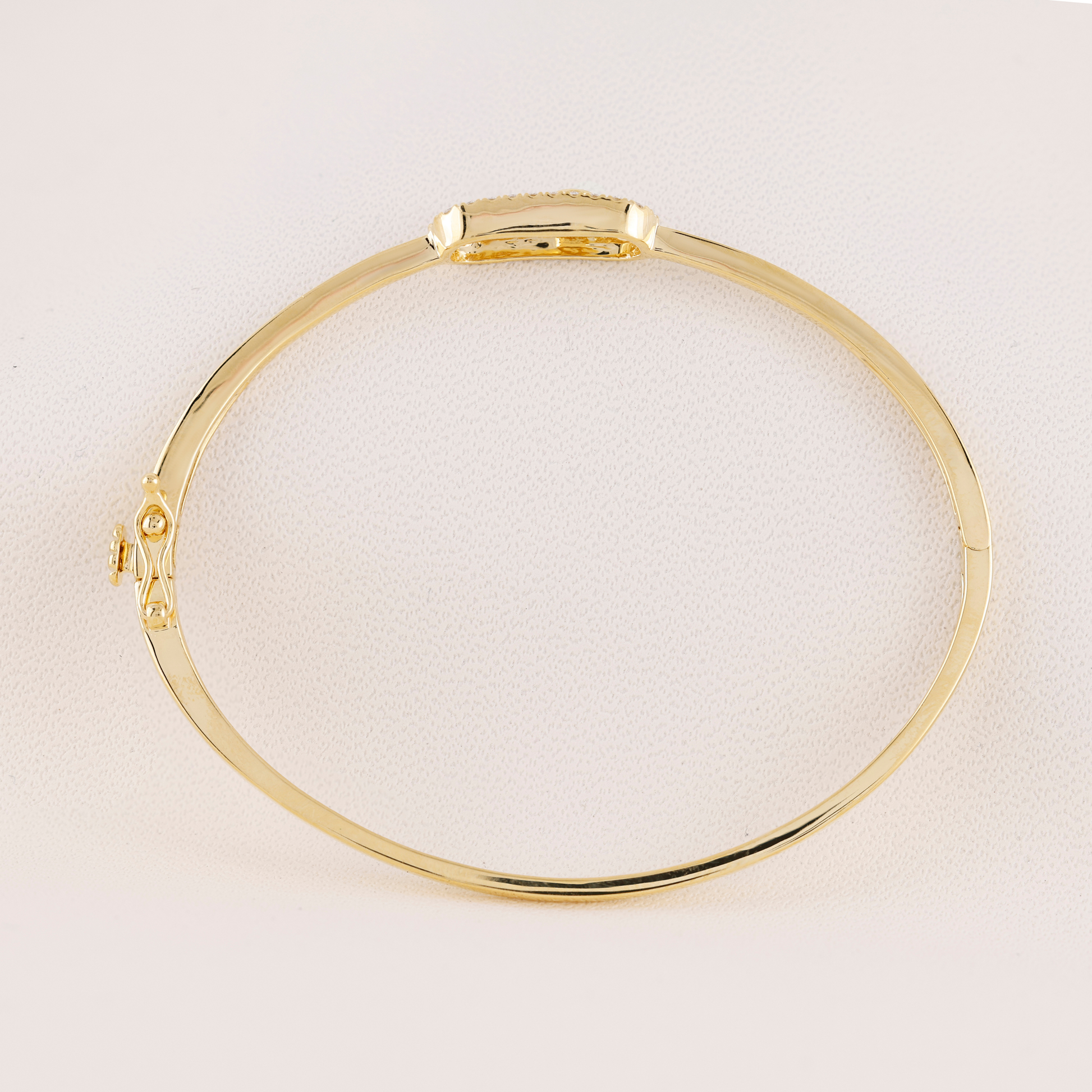 Gold bracelet on a light beige background