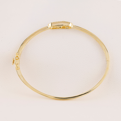 Gold bracelet on a light beige background