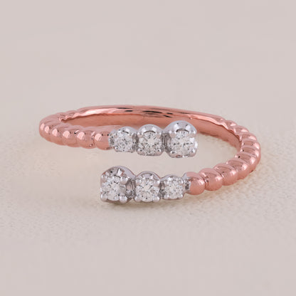 Rose gold ring with diamond accents on a light beige background