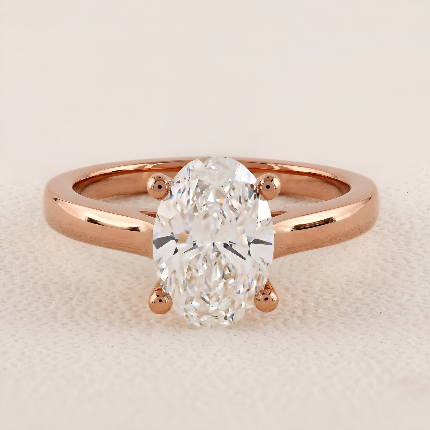 Rose gold ring with a large diamond on a light beige background