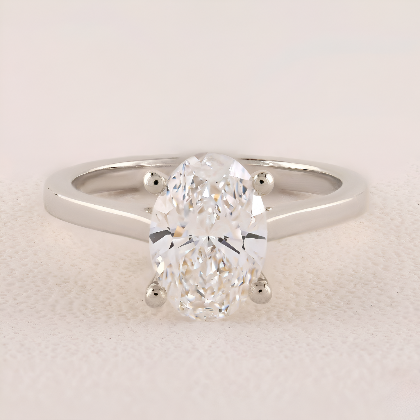 Diamond ring with a pear-shaped center stone on a light background