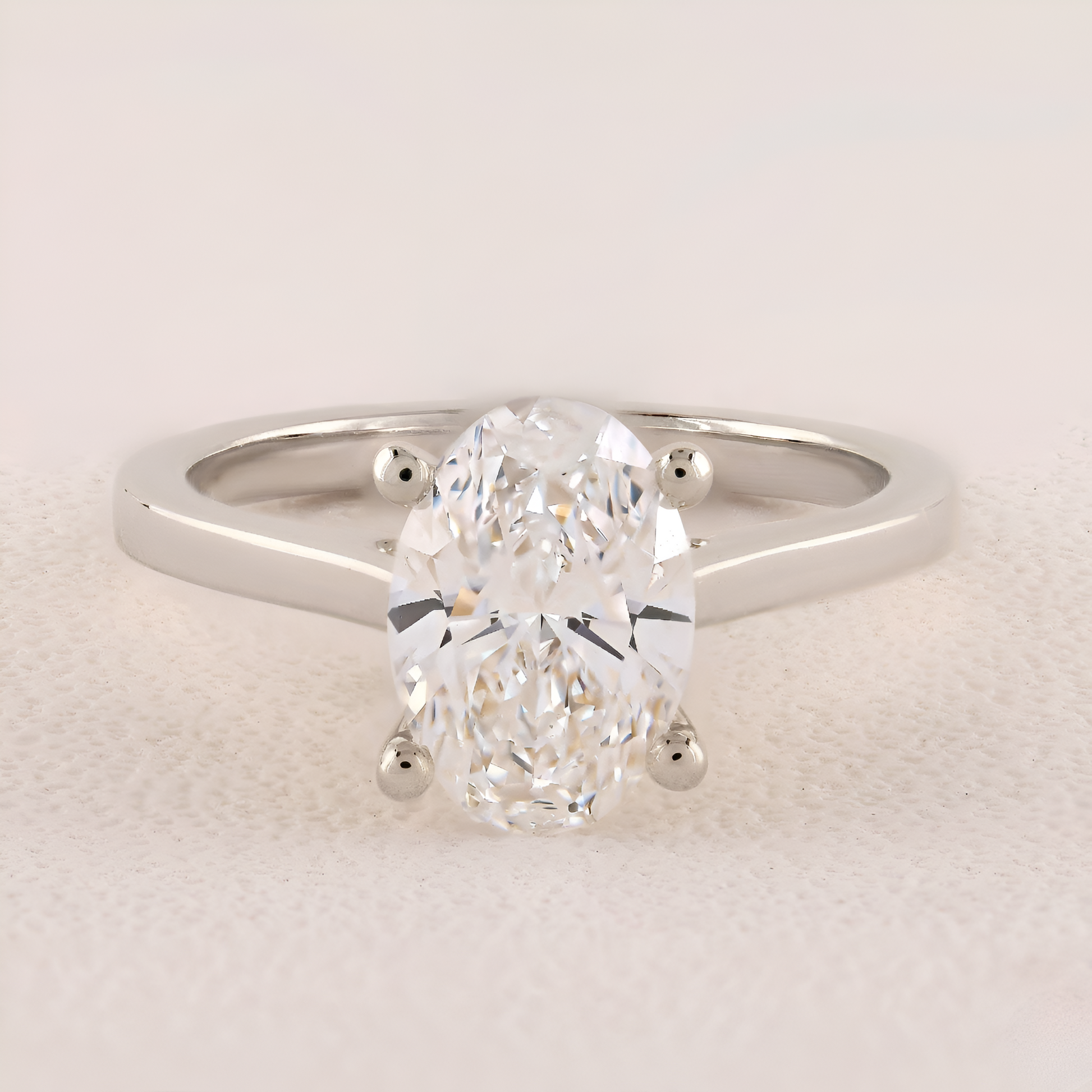 Diamond ring with a pear-shaped center stone on a light background