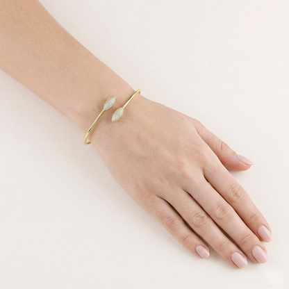 Gold bracelet on a hand against a white background