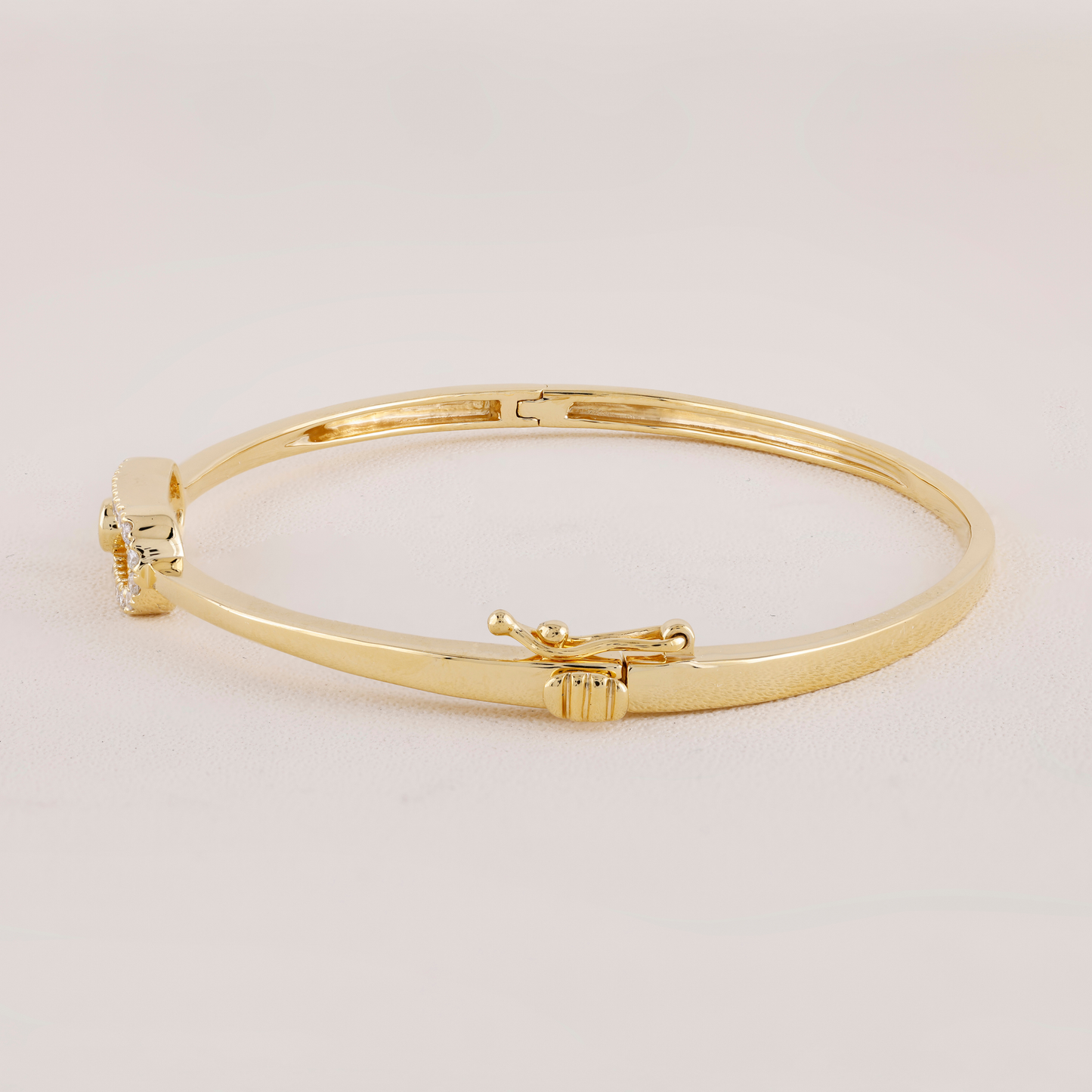 Gold bangle on a light beige background