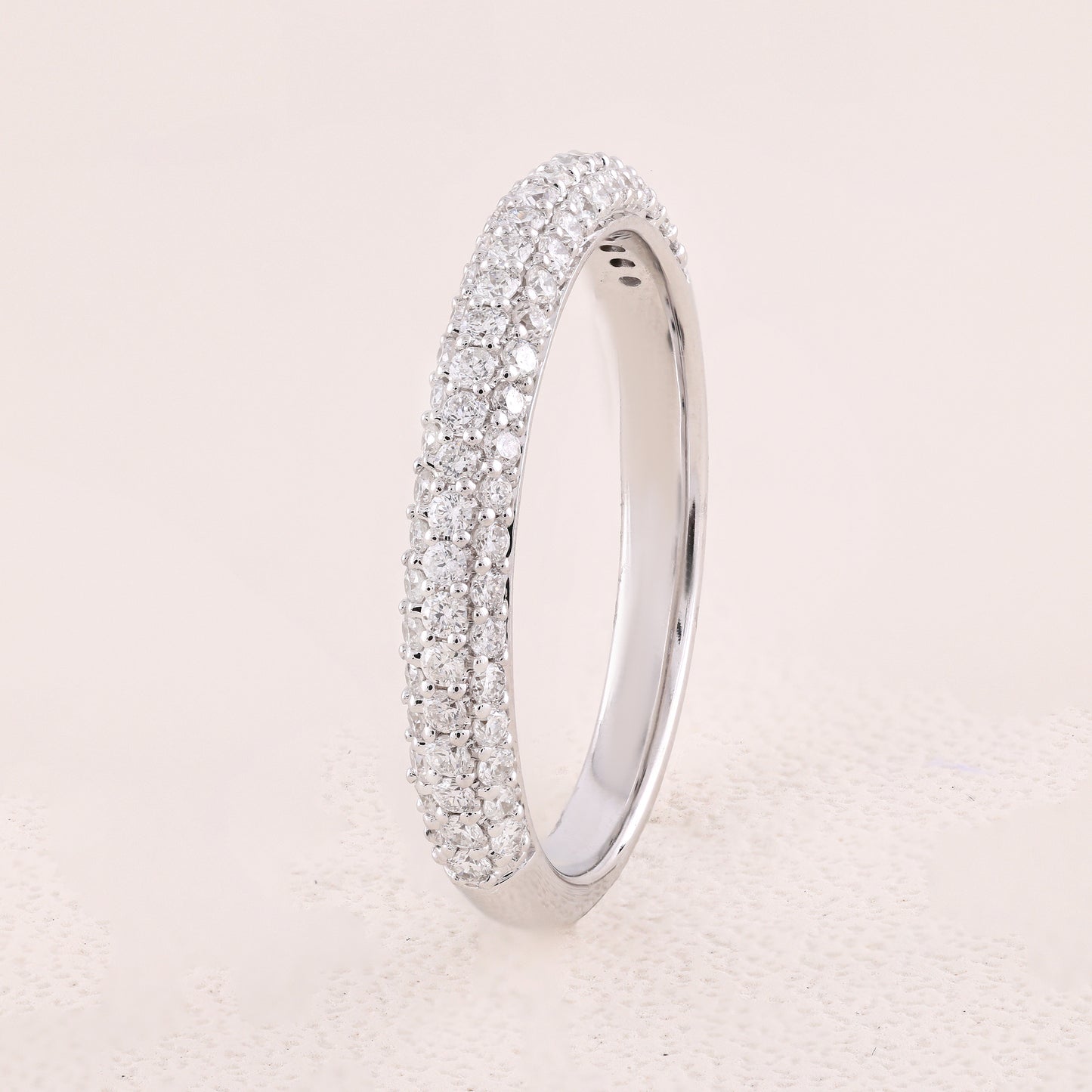 Silver ring with diamond accents on a light beige background