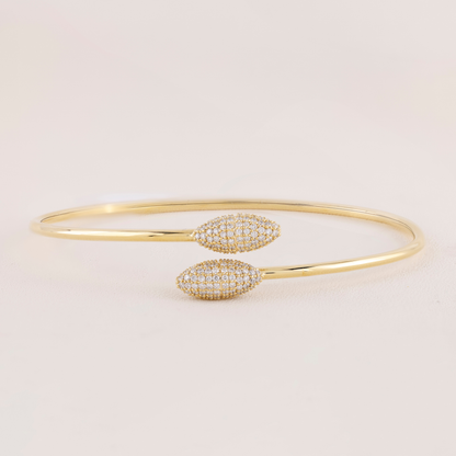Gold bracelet with diamond accents on a light beige background