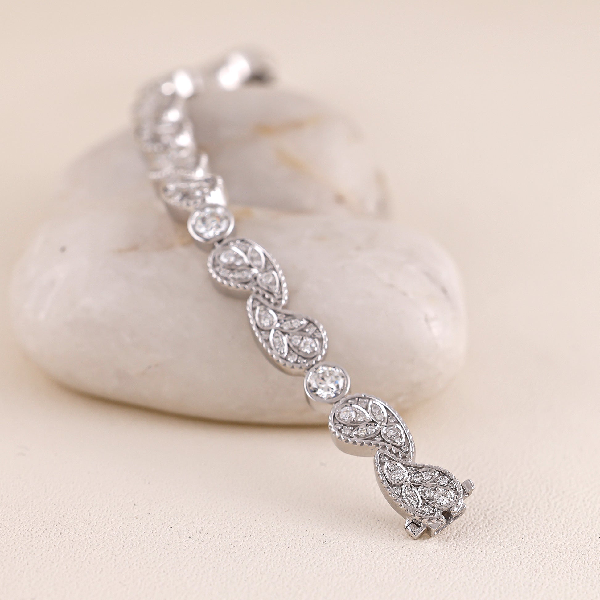 Silver bracelet with diamond accents on a light stone surface