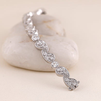 Silver bracelet with diamond accents on a light stone surface