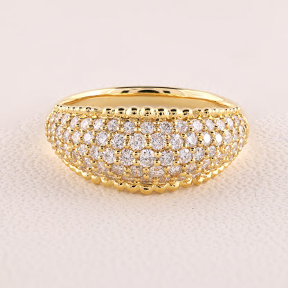 Gold ring with diamond accents on a light beige background