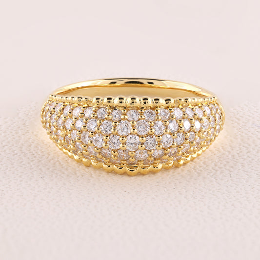 Gold ring with diamond accents on a light beige background