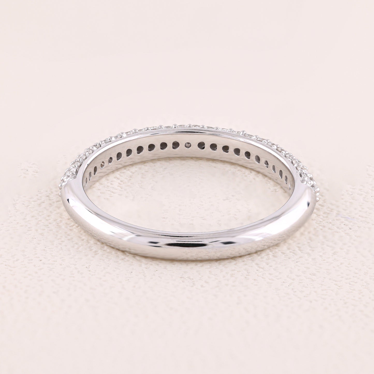 Silver ring with small stones on a light beige background