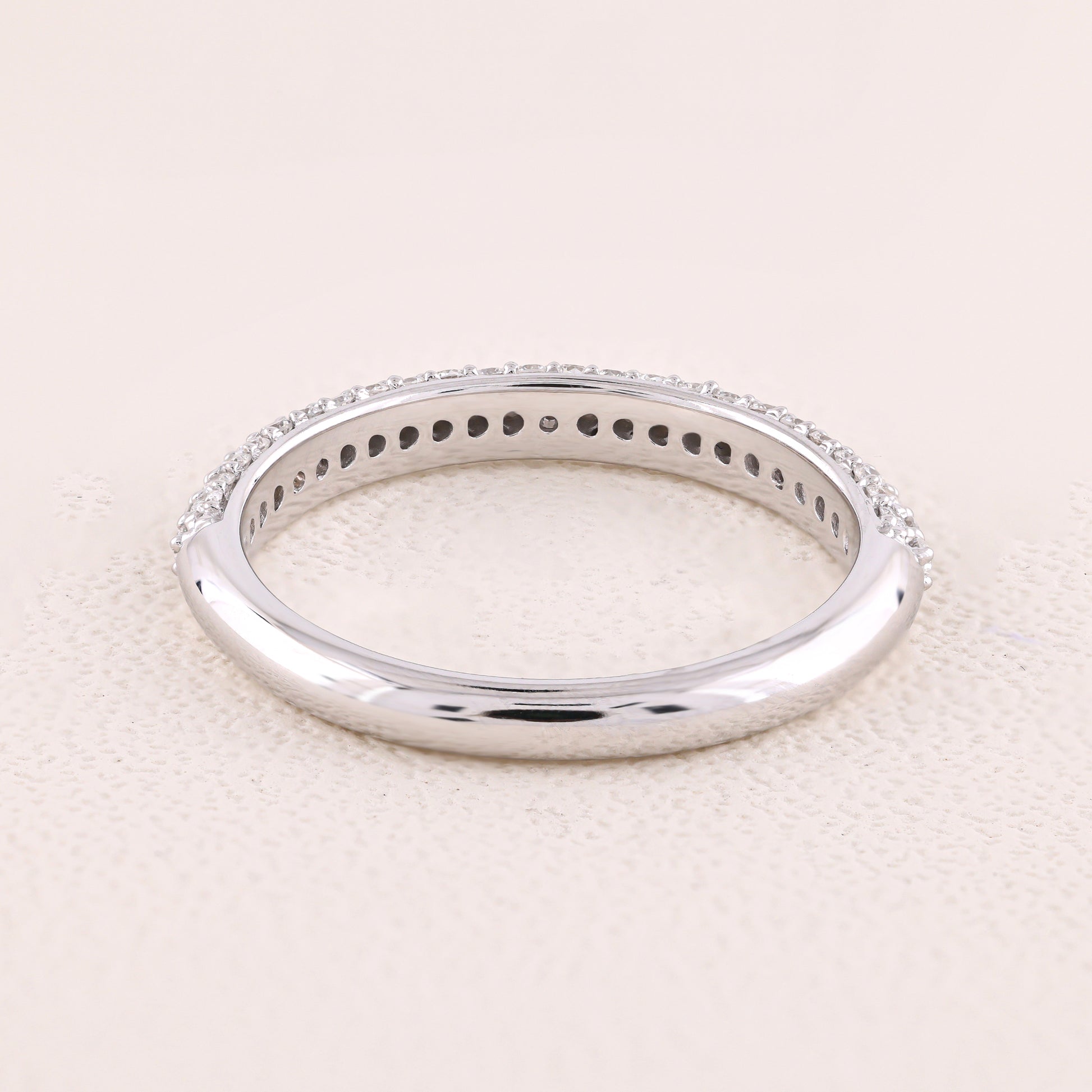 Silver ring with small stones on a light beige background