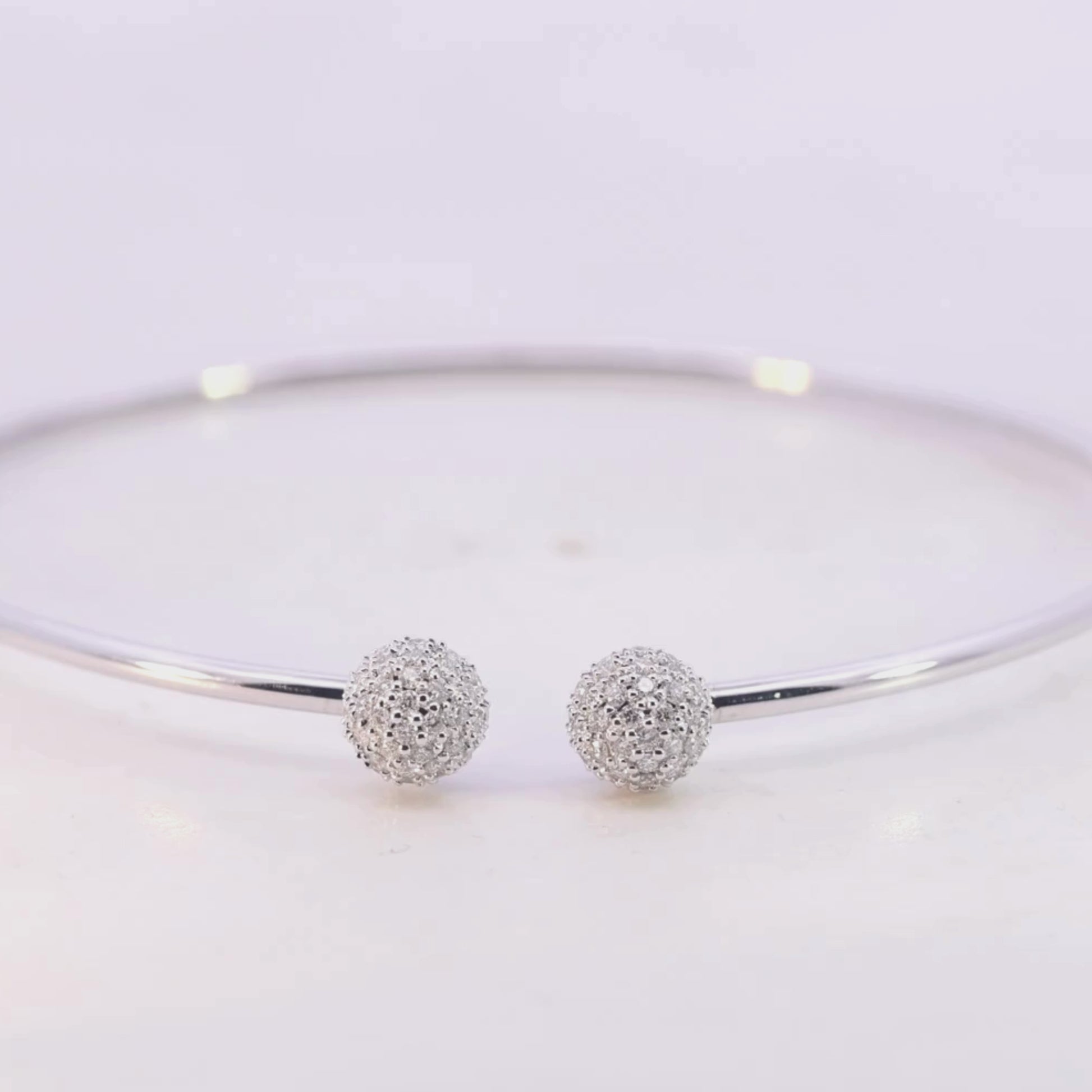 White Gold bracelet with two spherical charms on a light pink background Video