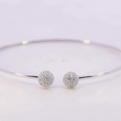 White Gold bracelet with two spherical charms on a light pink background Video