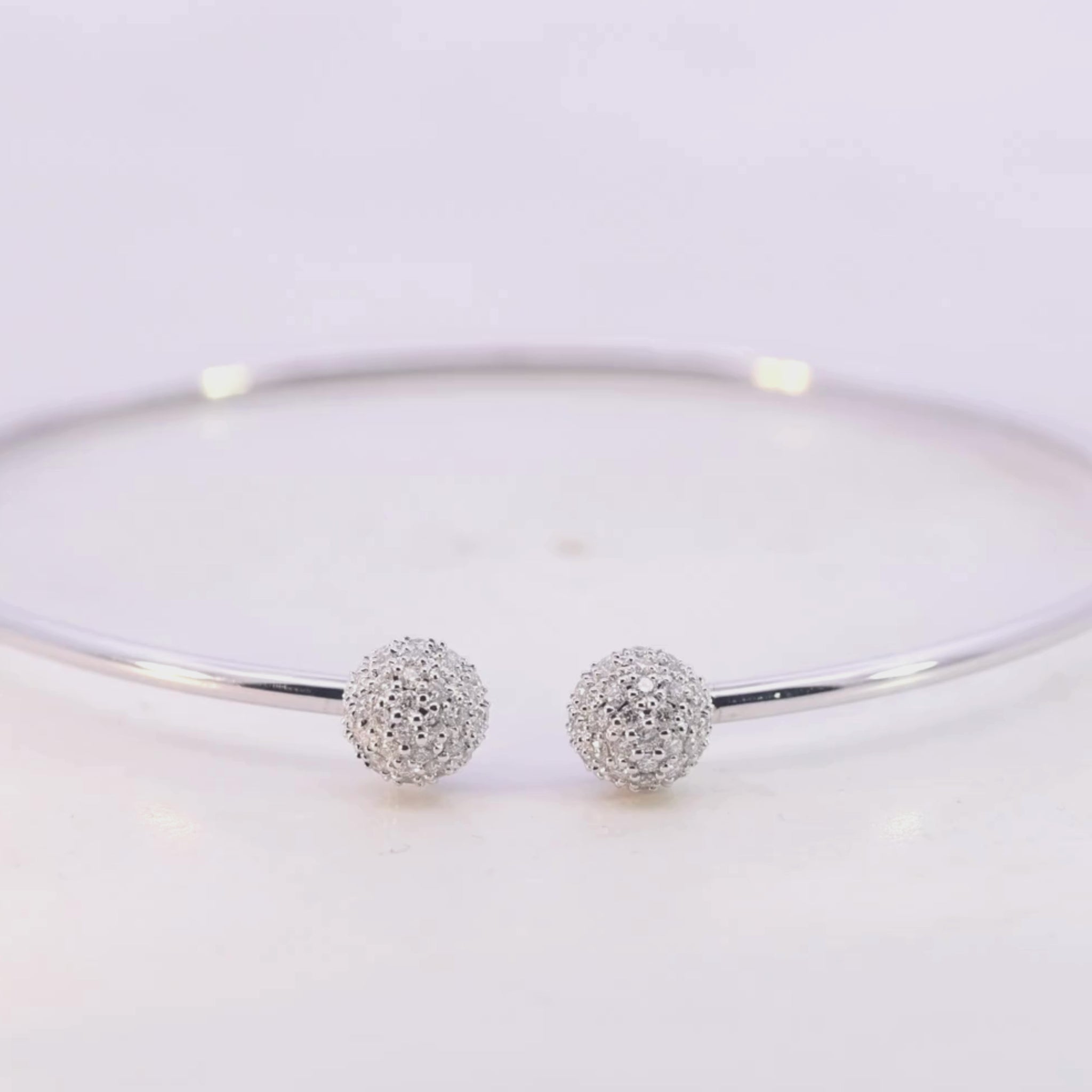 White Gold bracelet with two spherical charms on a light pink background Video