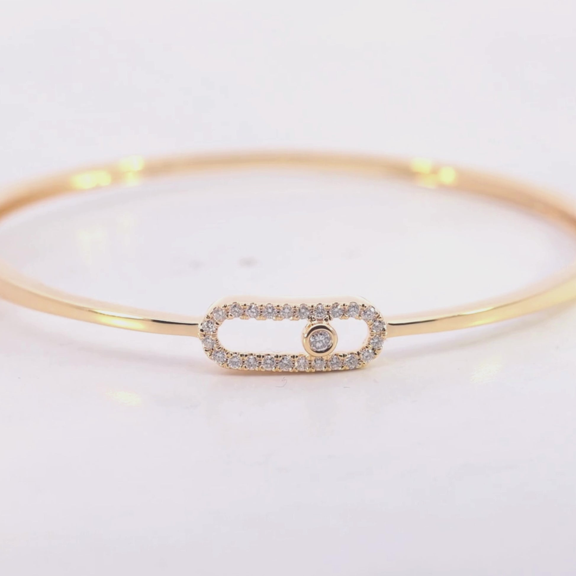 Gold bracelet with a smaall diamond on a beige background vdeo