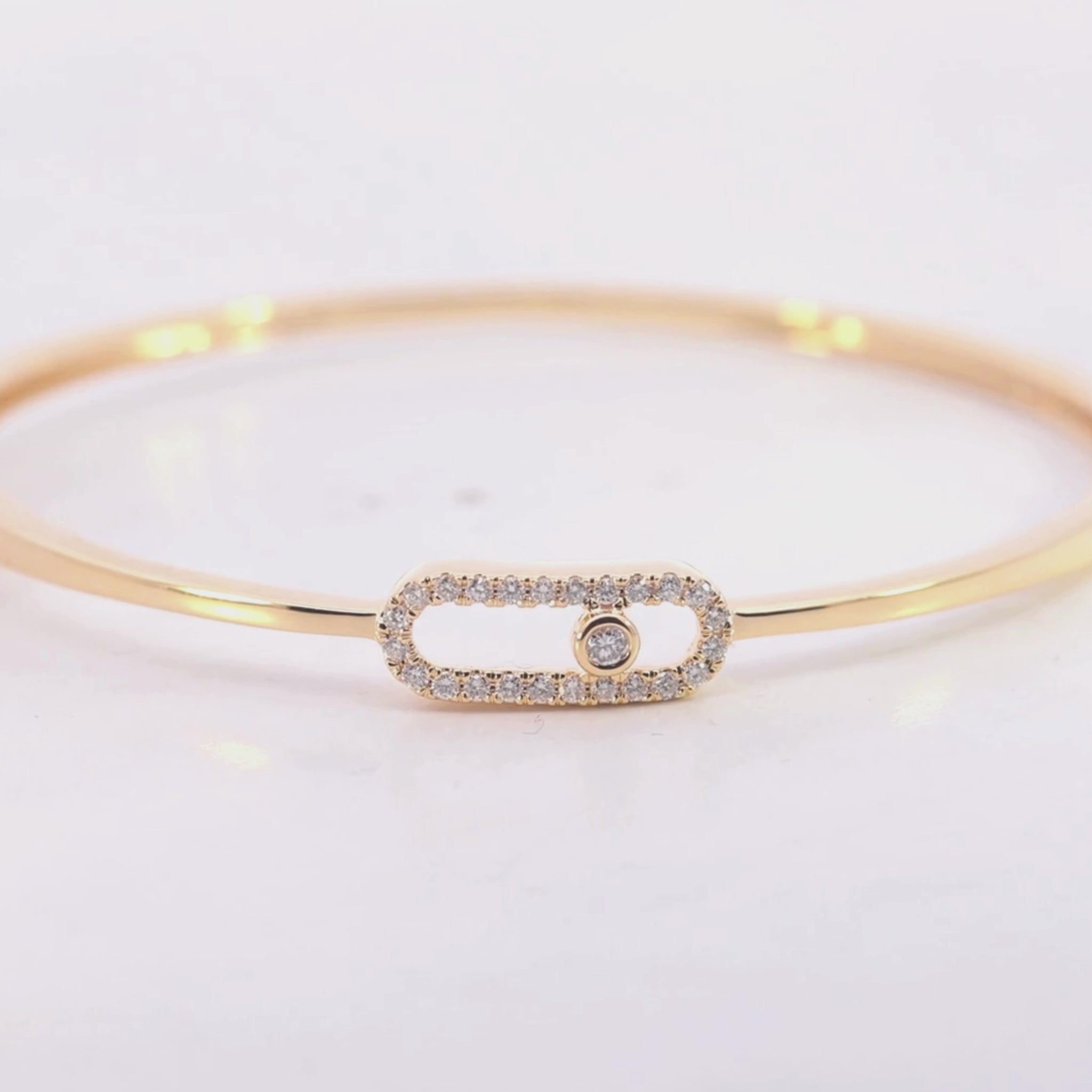 Gold bracelet with a smaall diamond on a beige background vdeo