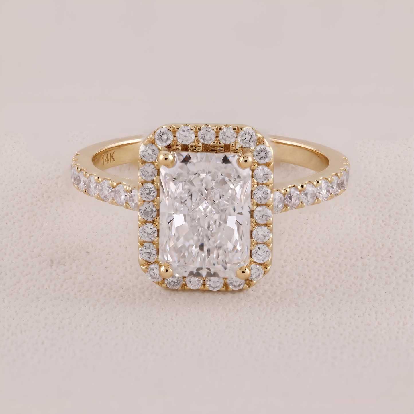 Gold ring with a large diamond and smaller diamonds on a beige background
