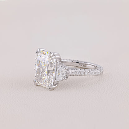 Diamond ring with a large central gemstone on a light gray background