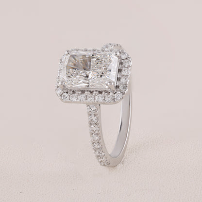Diamond ring with a large central gemstone and smaller stones on a light gray background