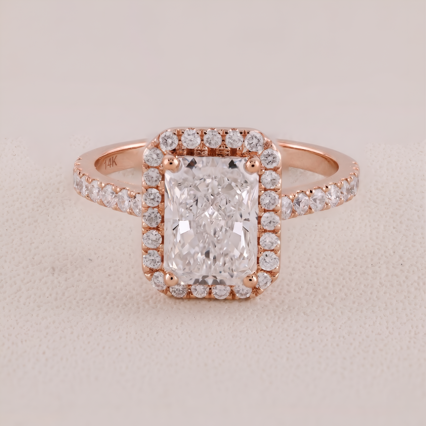 Rose gold ring with a large diamond and smaller diamonds on a beige background