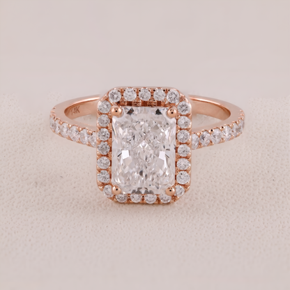Rose gold ring with a large diamond and smaller diamonds on a beige background