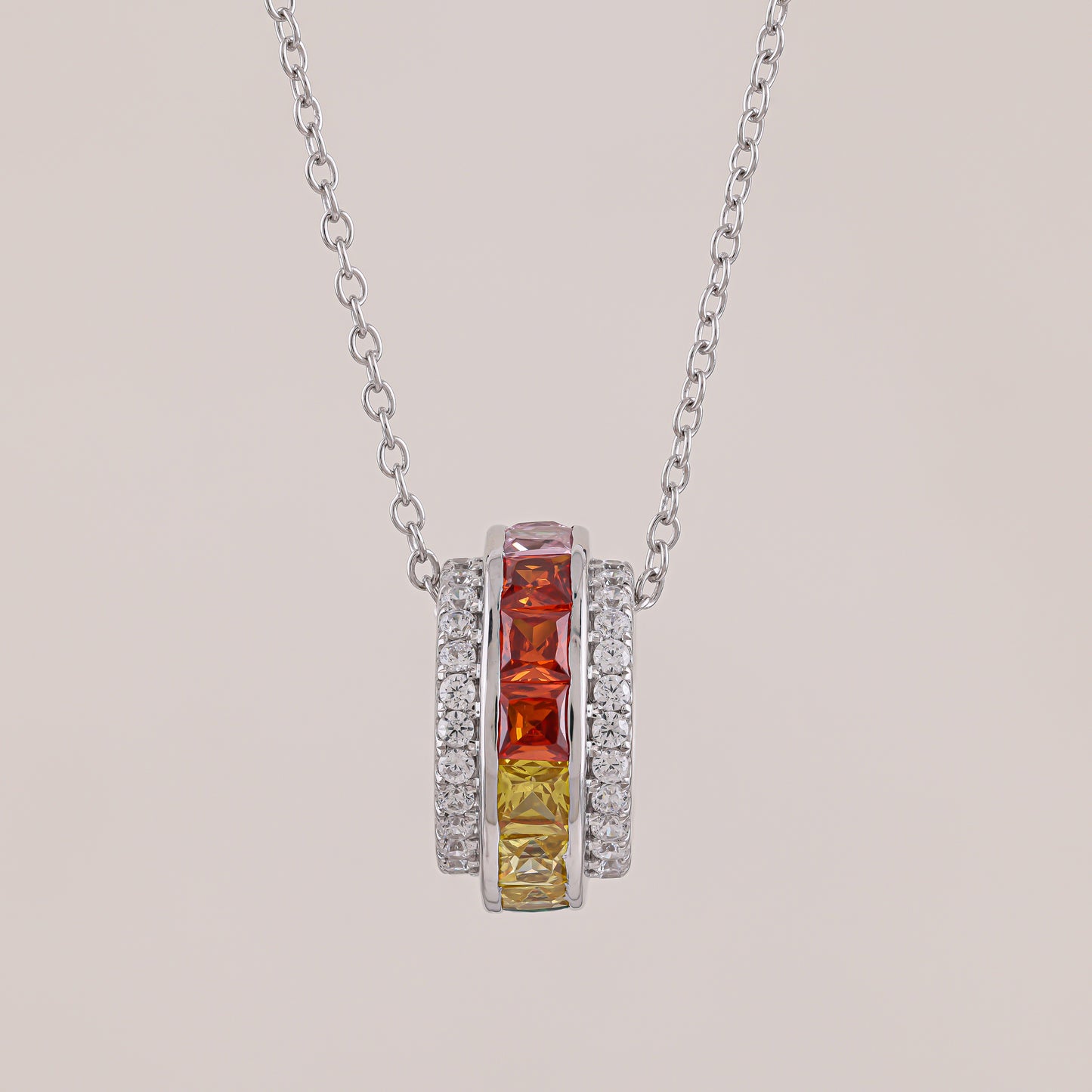 Necklace with a pendant featuring red and yellow gemstones on a light gray background