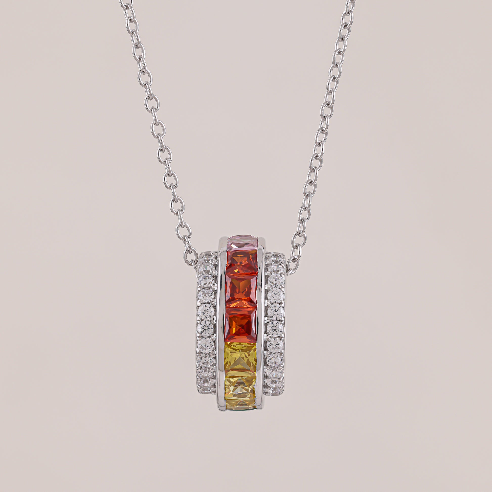 Necklace with a pendant featuring red and yellow gemstones on a light gray background
