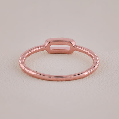 Rose gold ring on a light beige background