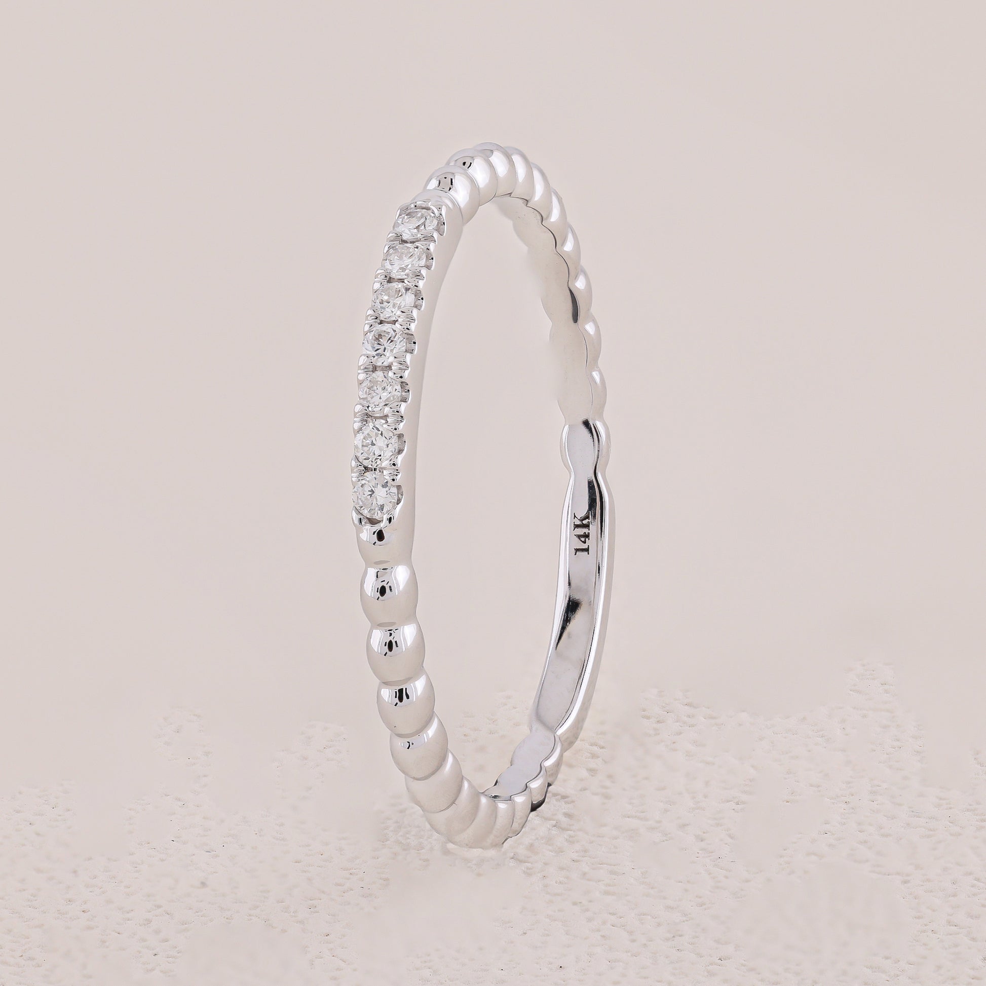 Silver ring with diamond accents on a light gray background