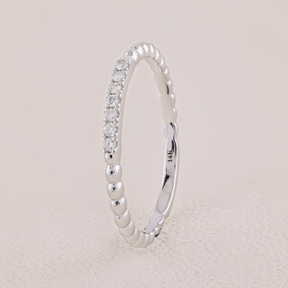 Silver ring with diamond accents on a light gray background