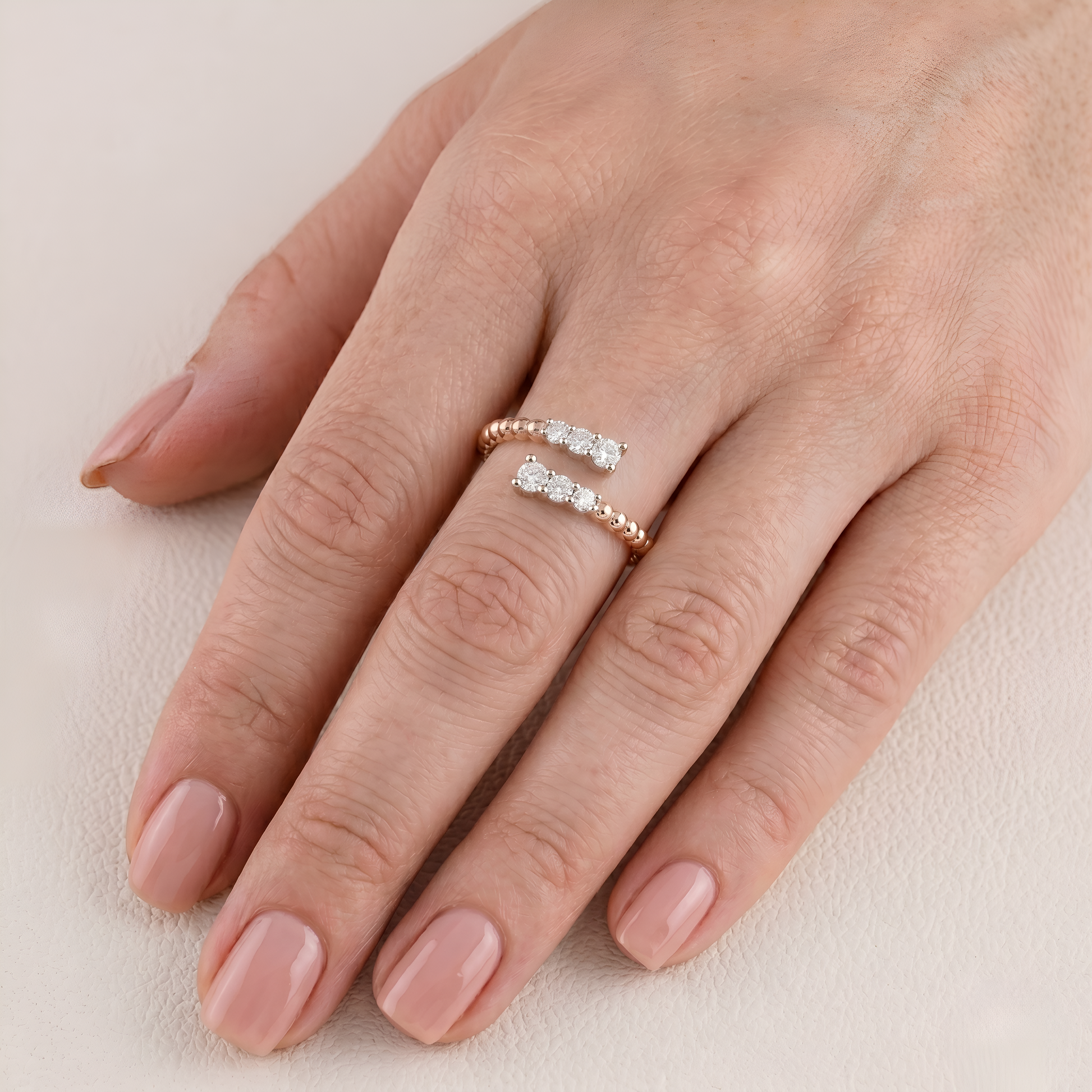 Hand wearing a diamond ring on a light background