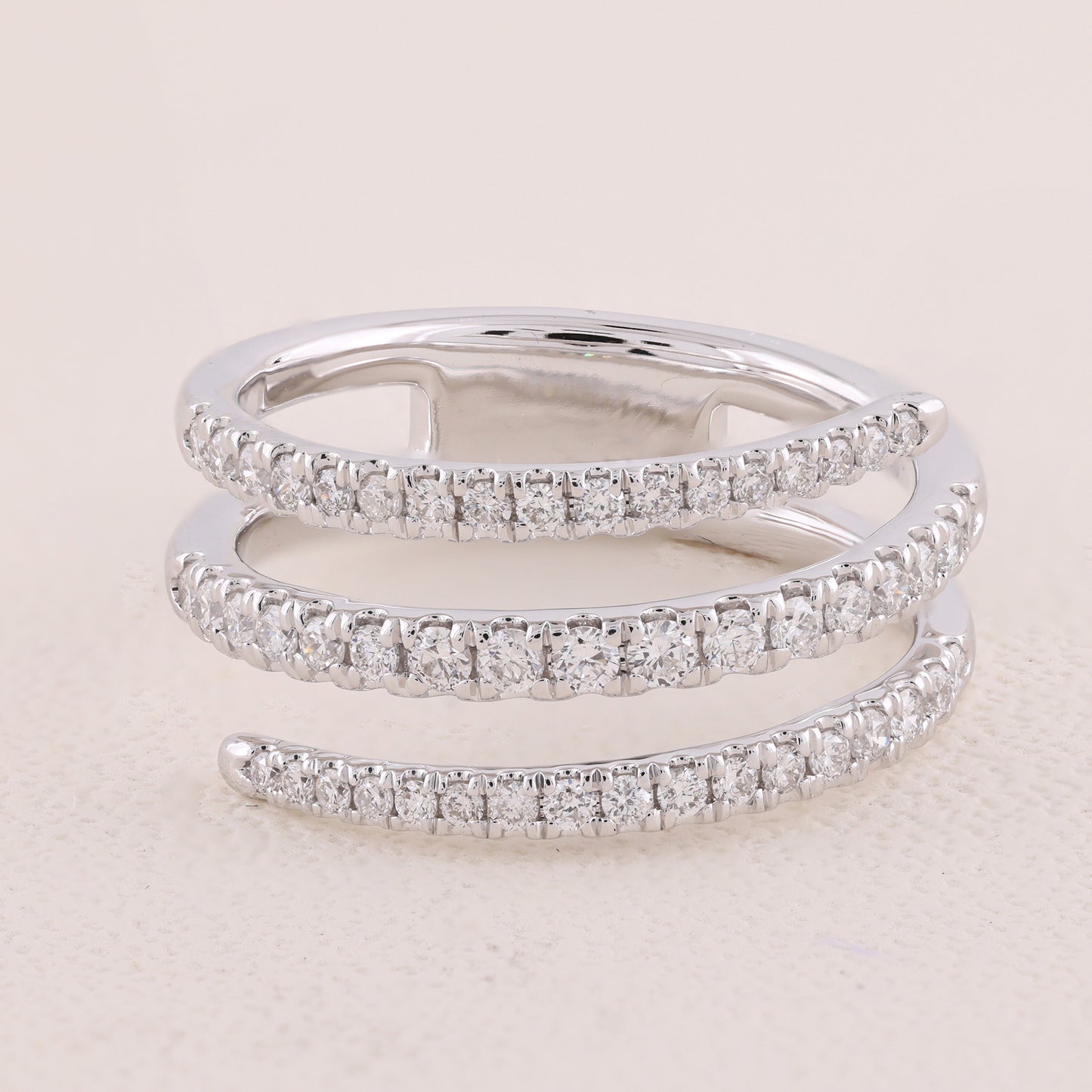 Two diamond-studded silver rings on a light beige background