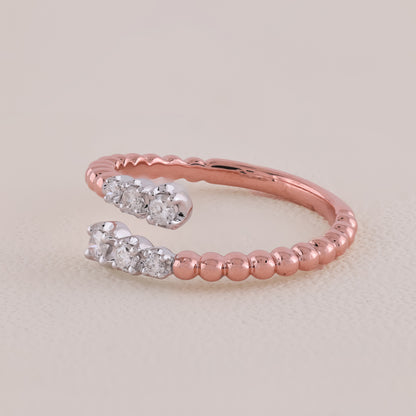 Rose gold ring with diamond accents on a light beige background